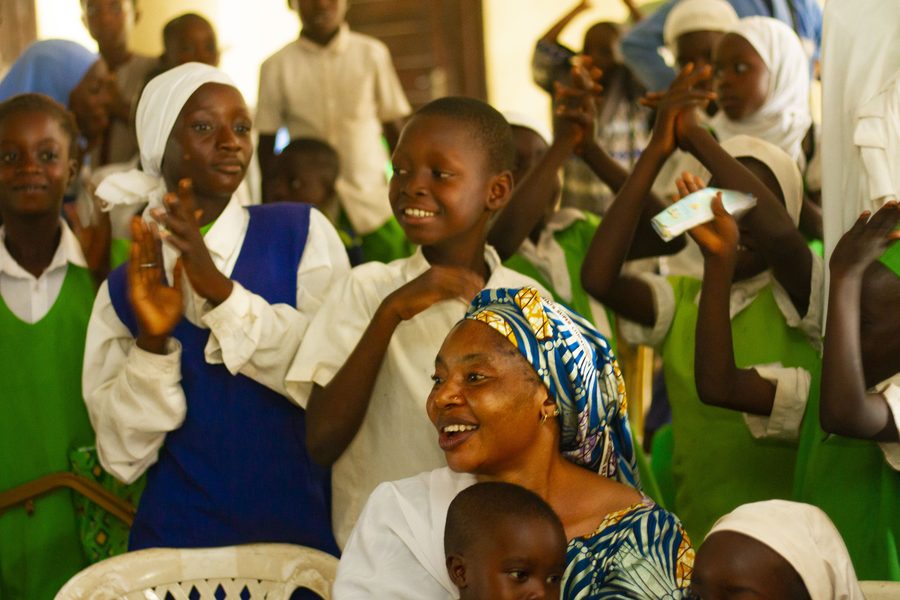 Students and a parent cheering and clapping during a FirstPage Foundation event